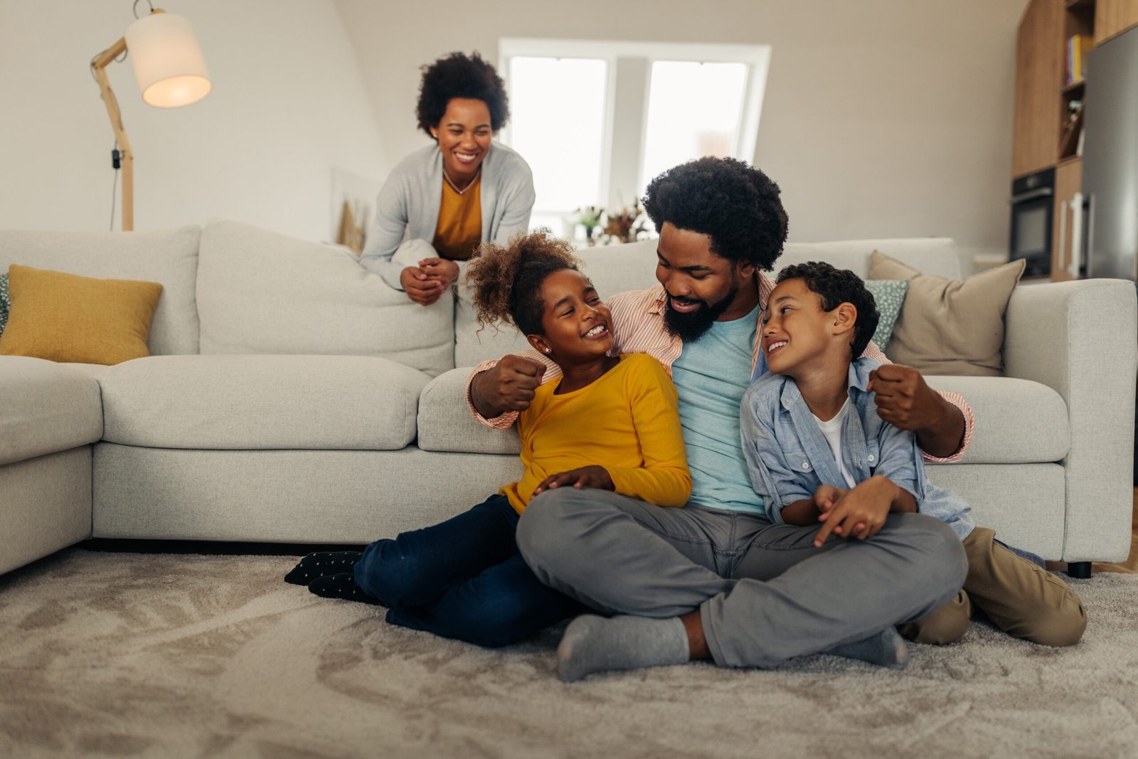 Afro parents and children having fun and smiling while spending weekend at home
